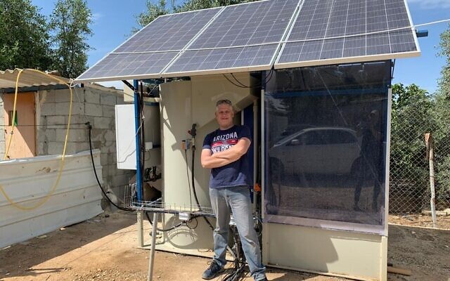 Clive Lipchin devant une unité de traitement des eaux usées hors réseau dans le village bédouin d'Umm Batin, près de Beer Sheva, dans le Negev (Autorisation : Institut Arava)