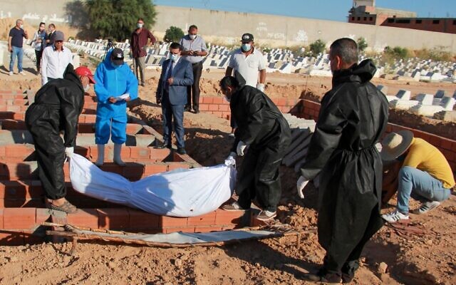 Des fossoyeurs dans un cimetière près de la ville côtière de Sfax, en Tunisie, portent des tenues de protection lors de l'enterrement de l'un des 52 migrants africains, décédé en mer lorsque leur bateau a chaviré près des îles tunisiennes de Kerkennah, le 15 juin 2020. (Hamdi ZAGHDANE / AFP) Des fossoyeurs dans un cimetière près de la ville côtière de Sfax, en Tunisie, portent des tenues de protection lors de l'enterrement de l'un des 52 migrants africains, décédé en mer lorsque leur bateau a chaviré près des îles tunisiennes de Kerkennah, le 15 juin 2020. (Hamdi ZAGHDANE / AFP)