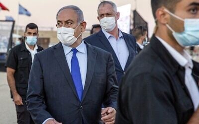 Le Premier ministre Benjamin Netanyahu (centre gauche) et son partenaire de coalition, le ministre de la Défense Benny Gantz (centre droit), arrivent pour une cérémonie de remise de diplômes aux nouveaux pilotes sur la base aérienne de Hatzerim, dans le sud d'Israël, le 25 juin 2020. (Ariel Schalit/Pool/AFP)