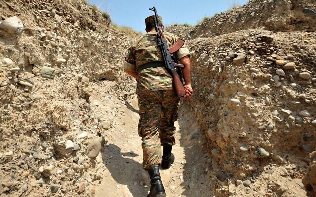 Un soldat arménien de la république autoproclamée du Haut-Karabagh marche dans une tranchée sur la ligne de front à la frontière avec l'Azerbaïdjan près de la ville de Martakert, le 11 juillet 2012. (KAREN MINASYAN / AFP) Un soldat arménien de la république autoproclamée du Haut-Karabagh marche dans une tranchée sur la ligne de front à la frontière avec l'Azerbaïdjan près de la ville de Martakert, le 11 juillet 2012. (KAREN MINASYAN / AFP)
