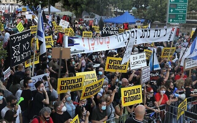 Les Israéliens protestent contre le Premier ministre Benjamin Netanyahu aux abords de sa résidence officielle à Jérusalem, le 14 juillet 2020 (Crédit : Menahem Kahana/AFP)