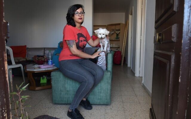 Emna Charki, 27 ans, une Tunisienne condamnée à six mois de prison par un tribunal de Tunis pour une parodie publiée sur Facebook liant le Coran et le COVID-19, le 14 juillet 2020 avec son chien, avant d'entrer en prison. (Fethi Belaid / AFP)