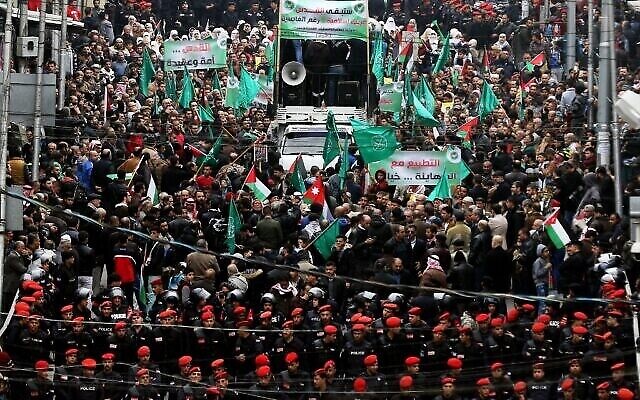 La police jordanienne en mission alors que les manifestants brandissent des drapeaux palestiniens et des Frères musulmans lors d'une manifestation contre la décision du président américain de reconnaître Jérusalem comme capitale d'Israël, dans la capitale jordanienne d’Amman, le 29 décembre 2017. (Khalil Mazraawi / AFP) La police jordanienne en mission alors que les manifestants brandissent des drapeaux palestiniens et des Frères musulmans lors d'une manifestation contre la décision du président américain de reconnaître Jérusalem comme capitale d'Israël, dans la capitale jordanienne d’Amman, le 29 décembre 2017. (Khalil Mazraawi / AFP)