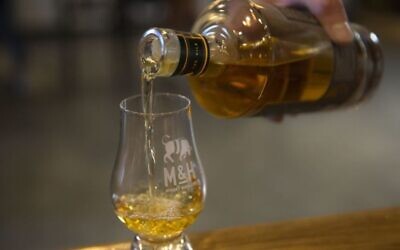 Sur cette photo du 10 août 2017, du whisky est versé à la distillerie de whisky Milk and Honey à Tel Aviv, Israël. (Autorisation : AP / Sebastian Scheiner)