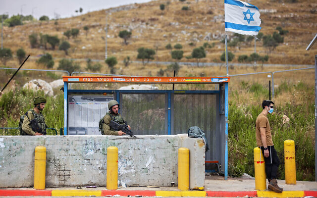 Des soldats de Tsahal gardent une station de bus à l'intersection de Tapuah, à côté de la ville de Naplouse en Cisjordanie, le 30 juin 2020. (AP/Oded Balilty)