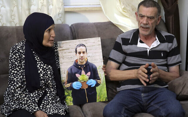 Les parents d'Iyad Halak, un Palestinien autiste mortellement blessé par les tirs de la police israélienne, avec Khiri, à droite, et sa mère Rana, pendant une interview à Jérusalem, le 3 juin 2020 (Crédit :  Mahmoud Illean/AP)