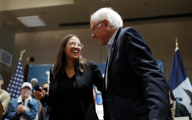 Bernie Sanders, à droite, rit avec la démocrate de New-York, Alexandria Ocasio-Cortez, lors d'un événement de campagne à Storm Lake, dans l'Iowa, le 26 janvier 2020 (Crédit : AP Photo/John Locher)