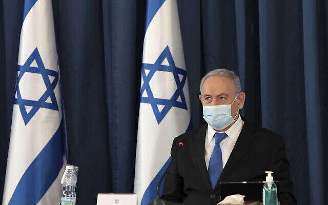 Le Premier ministre Benjamin Netanyahu porte un masque facial destiné à prévenir la propagation du coronavirus alors qu'il ouvre la réunion hebdomadaire de son cabinet, au ministère des Affaires étrangères, à Jérusalem, le 5 juillet 2020. (Gali Tibbon/AP) Le Premier ministre Benjamin Netanyahu porte un masque facial destiné à prévenir la propagation du coronavirus alors qu'il ouvre la réunion hebdomadaire de son cabinet, au ministère des Affaires étrangères, à Jérusalem, le 5 juillet 2020. (Gali Tibbon/AP)