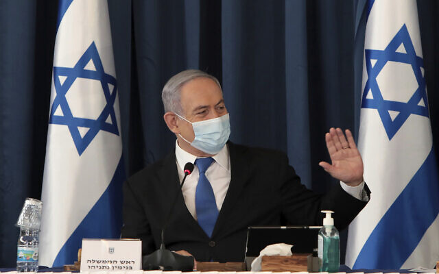 Le Premier ministre Benjamin Netanyahu porte un masque facial pour contribuer à prévenir la propagation du coronavirus alors qu'il préside la réunion hebdomadaire du cabinet, au ministère des Affaires étrangères, à Jérusalem, le 5 juillet 2020. (Gali Tibbon/Pool via AP) Le Premier ministre Benjamin Netanyahu porte un masque facial pour contribuer à prévenir la propagation du coronavirus alors qu'il préside la réunion hebdomadaire du cabinet, au ministère des Affaires étrangères, à Jérusalem, le 5 juillet 2020. (Gali Tibbon/Pool via AP)