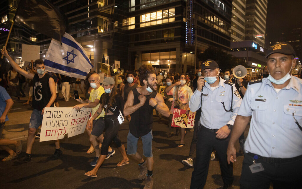 Un manifestant israélien se dispute avec des officiers de police lors d'une manifestation contre la corruption près de la maison du ministre israélien de la Sécurité publique à Tel Aviv, mardi 28 juillet 2020. (AP Photo/Sebastian Scheiner) Un manifestant israélien se dispute avec des officiers de police lors d'une manifestation contre la corruption près de la maison du ministre israélien de la Sécurité publique à Tel Aviv, mardi 28 juillet 2020. (AP Photo/Sebastian Scheiner)