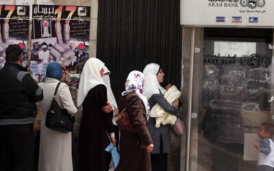 Des Palestiniens reçoivent leurs salaires dans une banque de Ramallah, en Cisjordanie, le 17 mai 2011 (Crédit : Issam Rimawi/FLASH90)