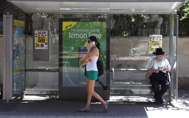Illustration : Une femme parlant sur son téléphone portable à un arrêt de bus, à Tel Aviv, le 24 août 2012. (Crédit : Yaakov Naumi/Flash90) Illustration : Une femme parlant sur son téléphone portable à un arrêt de bus, à Tel Aviv, le 24 août 2012. (Crédit : Yaakov Naumi/Flash90)