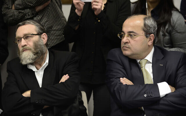 Le député arabe Ahmad Tibi (à droite) avec Moshe Gafni (à gauche) du parti Yahadout HaTorah lors d'une réunion de l'opposition à la Knesset, le 9 mars 2014. (Tomer Neuberg/Flash90)