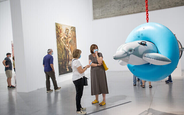 Des visiteurs masqués à l'exposition de Jeff Koons au musée d'art de Tel Aviv le 3 juin 2020 (Miriam Alster/FLASH90)