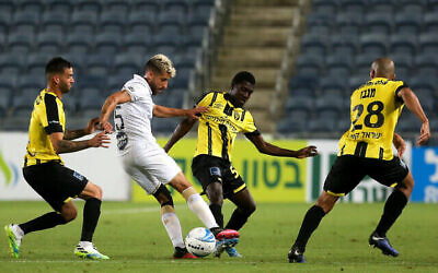 Illustration : Un joueur du Maccabi Tel Aviv, en blanc, dribble le ballon entre deux joueurs adverses lors d'un match contre le Beitar Jerusalem à Jérusalem, le 8 juin 2020. (Flash90)