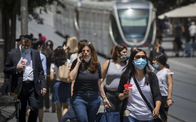 Une femme utilise son téléphone portable alors que des personnes portent des masques de protection par peur du coronavirus dans le centre-ville de Jérusalem, le 8 juin 2020. (Olivier Fitoussi/Flash90) Une femme utilise son téléphone portable alors que des personnes portent des masques de protection par peur du coronavirus dans le centre-ville de Jérusalem, le 8 juin 2020. (Olivier Fitoussi/Flash90)