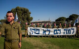 Des amis des soldats Oron Shaul et Hadar Goldin portent des masques à leur effigie pour réclamer le retour de leurs dépouilles, devant la Knesset le 1er juillet 2020. (Crédit : Yonatan Sindel/Flash90)
