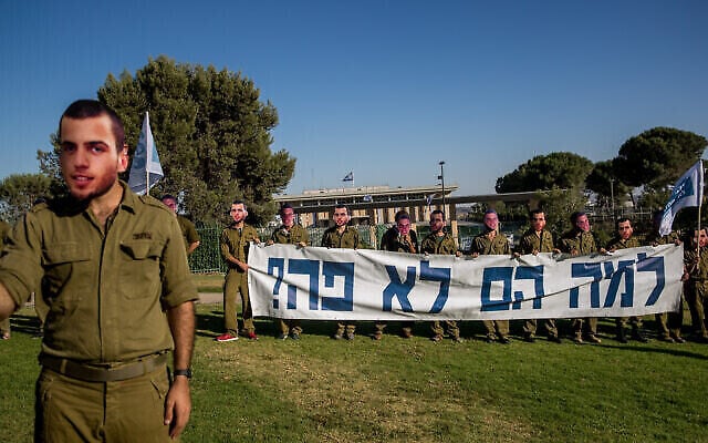 Des amis des soldats Oron Shaul et Hadar Goldin portent des masques à leur effigie pour réclamer le retour de leurs dépouilles, devant la Knesset le 1er juillet 2020. (Crédit : Yonatan Sindel/Flash90) Des amis des soldats Oron Shaul et Hadar Goldin portent des masques à leur effigie pour réclamer le retour de leurs dépouilles, devant la Knesset le 1er juillet 2020. (Crédit : Yonatan Sindel/Flash90)