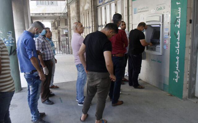 Des Palestiniens font la queue à un distributeur automatique de billets dans la ville de Naplouse, en Cisjordanie, le 2 juillet 2020. (Nasser Ishtayeh/Flash90) Des Palestiniens font la queue à un distributeur automatique de billets dans la ville de Naplouse, en Cisjordanie, le 2 juillet 2020. (Nasser Ishtayeh/Flash90)