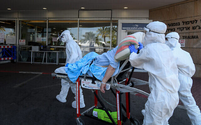 Des employés du Magen David Adom portant des vêtements de protection transfèrent un patient à l'unité de lutte contre le coronavirus au centre médical Sheba à Ramat Gan, le 8 juillet 2020. (Flash90)