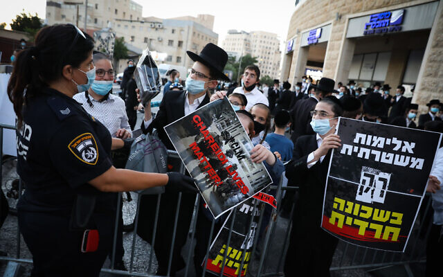 Des hommes et des jeunes ultra-orthodoxes pendant une manifestation contre le confinement de leurs quartiers de Romema et de Kiryat Belz, à Jérusalem, une mise à l'isolement entraînée par la propagation du coronavirus, le 12 juillet 2020 (Crédit :  Olivier Fitoussi/Flash90)