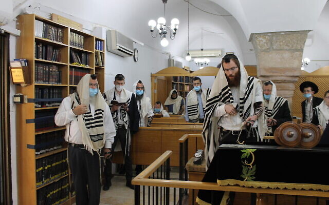 Des hommes masqués prient dans la synagogue Hurva de Jérusalem, le 21 mai 2020. (Sam Sokol)