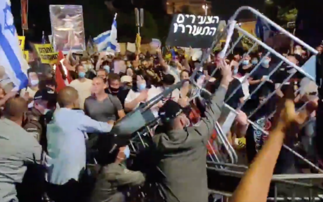 Des manifestants tentent de retirer les barrières durant une manifestation contre le Premier ministre Benjamin Netanyahu aux abords de sa résidence à Jérusalem, le 14 juillet 2020. (Capture d'écran : Twitter)