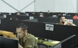 Illustration : des soldats au téléphone au siège du commandement du front intérieur de l'armée lors d'une visite du responsable gouvernemental du coronavirus, le Prof. Ronni Gamzu, dans une vidéo publiée par Tsahal le 29 juillet 2020. (Screen capture: Israel Defense Forces)