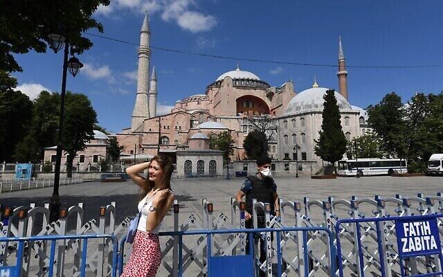 Une femme prend la pose devant la Basilique Sainte-Sophie à Istanbul, le 11 juillet 2020. (Crédit : Ozan Kose/AFP)