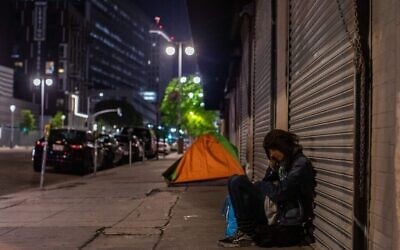 On peut voir une femme sans domicile fixe dormir dans la rue Skid Row pendant le COVID-19, l'épidémie de coronavirus à Los Angeles, en Californie le 16 mai 2020. (Apu Gomes/AFP via Getty Images)