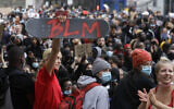 Un manifestant tient une planche de skateboard avec les initiales de Black Lives Matter à Londres, le mercredi 3 juin 2020 lors d'une manifestation après la mort de George Floyd, un homme noir qui es mort après avoir été maîtrisé par des officiers de police à Minneapolis le 25 mai. (AP Photo/Kirsty Wigglesworth)