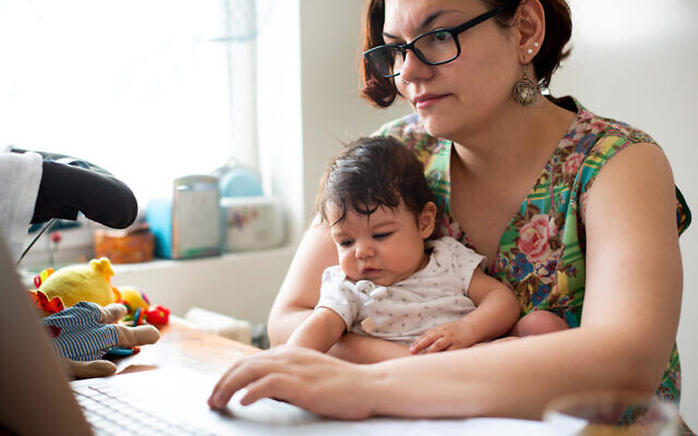 Une mère au travail avec son bébé sur les genoux. (StockRocket ; iStock par Getty Images)