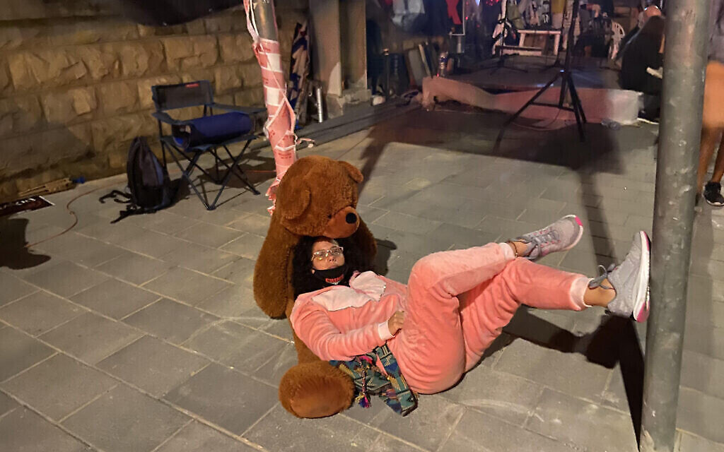 Mirav Ben-Uziel, en pyjama rose et avec son ours en peluche, devant la résidence du Premier ministre à Jérusalem, le 16 juillet 2020. (Anat Peled)