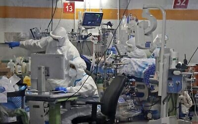 Des médecins travaillent avec des patients CoVid-19 dans l’unité d'isolement du centre médical Sheba à Ramat Gan, le 29 juillet 2020. (Autorisation : JACK GUEZ / AFP)