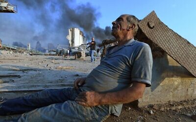 Un homme est assis au sol en attendant de l'aide au port de Beyrouth après l'énorme explosion qui a frappé le coeur de la capitale libanaise le 4 août 2020. 
(Photo by - / AFP)