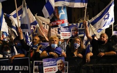 Des Israéliens rassemblés en soutien au Premier ministre Benjamin Netanyahu près de sa résidence à Jérusalem, le 20 août 2020. (Crédit : Menahem Kahana / AFP)