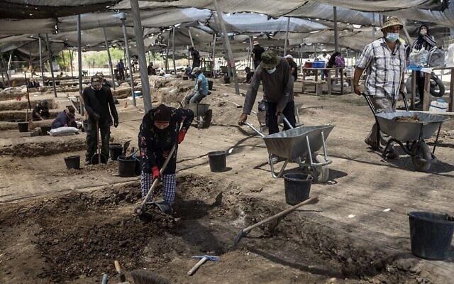 Des ouvriers fouillent un site où d'un tas de pièces d'or datant du califat abbasside a été mis au jour, sur un site archéologique près de Tel Aviv. (Crédit : Heidi Levine / POOL / AFP)