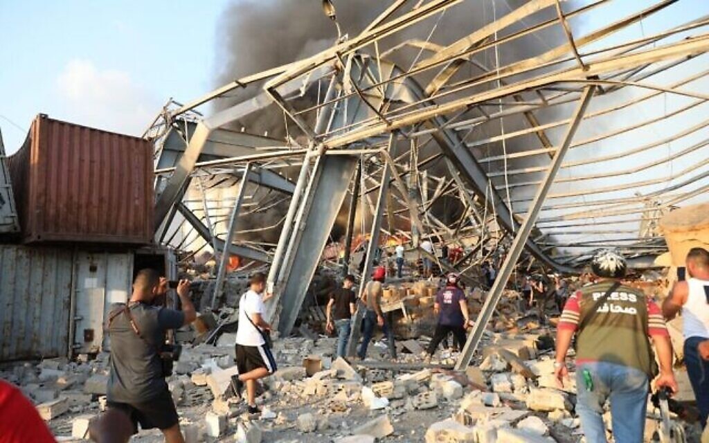 Des gens sur le site d'une explosion survenue dans la capitale libanaise Beyrouth, le 4 août 2020. (Crédit : Anwar AMRO / AFP)