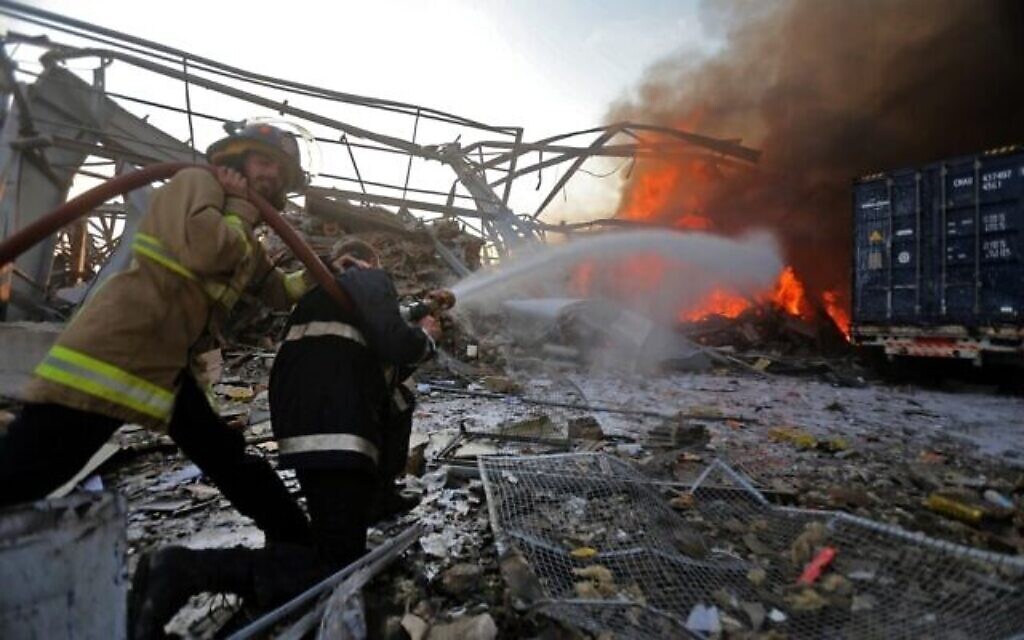 Des pompiers libanais éteignent un incendie sur la scène d'une explosion dans le port de Beyrouth, capitale du Liban, le 4 août 2020. (Crédit : STR / AFP)