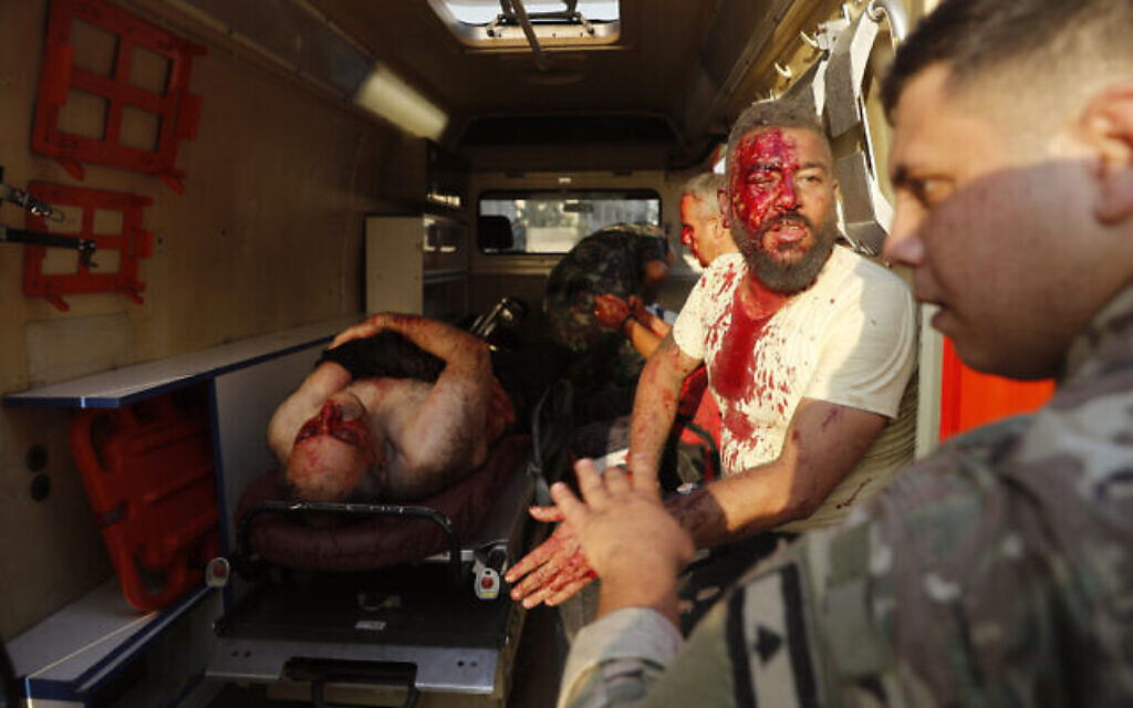 Un soldat libanais, à droite, avec des blessés dans une ambulance, sur les lieux de l'explosion qui a frappé le port de Beyrouth, au Liban, le mardi 4 août 2020. (Crédit : AP Photo / Hussein Malla)