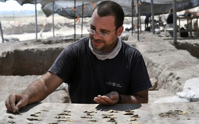 Shahar Krispin, expert numismate de l'Autorité israélienne des antiquités, compte les pièces d'or. (Crédit : Yoli Schwartz, Israel Antiquities Authority)