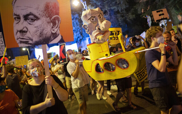 Des manifestants scandent des slogans et brandissent des pancartes lors d'un rassemblement contre le Premier ministre Benjamin Netanyahu devant sa résidence à Jérusalem, le samedi 1er août 2020. (AP Photo/Oded Balilty)