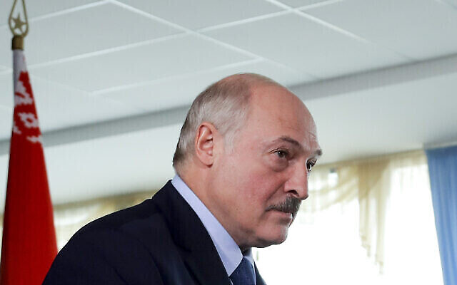 Le président biélorusse Alexandre Loukachenko après avoir voté dans un bureau de vote arborant le drapeau biélorusse, lors des élections présidentielles à Minsk, Biélorussie, le 9 août 2020. (Crédit : AP Photo/Sergei Grits) Le président biélorusse Alexandre Loukachenko après avoir voté dans un bureau de vote arborant le drapeau biélorusse, lors des élections présidentielles à Minsk, Biélorussie, le 9 août 2020. (Crédit : AP Photo/Sergei Grits)
