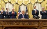Le président américain de l'époque, Donald Trump, au centre, est entouré de l'ambassadeur en Israël de l'époque, David Friedman, à gauche, et du conseiller principal de l'époque, Jared Kushner, dans le bureau ovale, le 12 août 2020. (Crédit : AP/Andrew Harnik)