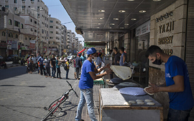 Des Palestiniens font la queue devant une boulangerie pour acheter du pain pendant le blocus de 48 heures imposé suite à la découverte des premiers cas de coronavirus dans la bande de Gaza, le 25 août 2020. (AP/Khalil Hamra) Des Palestiniens font la queue devant une boulangerie pour acheter du pain pendant le blocus de 48 heures imposé suite à la découverte des premiers cas de coronavirus dans la bande de Gaza, le 25 août 2020. (AP/Khalil Hamra)