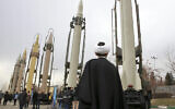 Un religieux iranien regarde des missiles sol-sol fabriqués en Iran pendant un spectacle militaire marquant le 40è anniversaire de la révolution islamique iranienne qui avait renversé le Shah, soutenu par les Etats-Unis, à la Grande mosquée  Imam Khomeini de Téhéran en Iran, le 3 février 2019 (Crédit : AP Photo/Vahid Salemi)