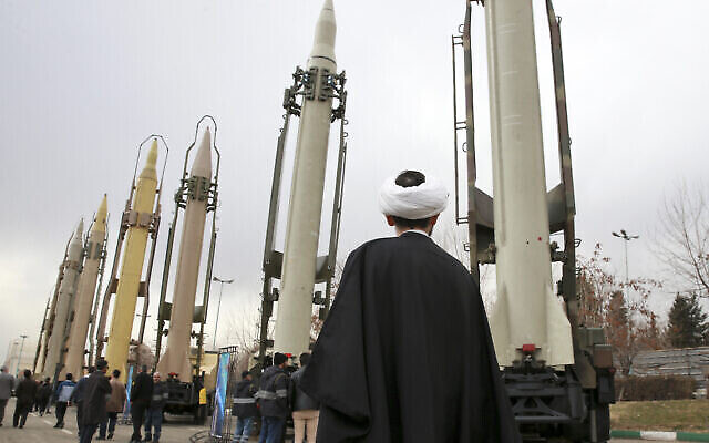 Un religieux iranien regarde des missiles sol-sol fabriqués en Iran pendant un spectacle militaire marquant le 40è anniversaire de la révolution islamique iranienne qui avait renversé le Shah, soutenu par les Etats-Unis, à la Grande mosquée Imam Khomeini de Téhéran en Iran, le 3 février 2019 (Crédit : AP Photo/Vahid Salemi) Un religieux iranien regarde des missiles sol-sol fabriqués en Iran pendant un spectacle militaire marquant le 40è anniversaire de la révolution islamique iranienne qui avait renversé le Shah, soutenu par les Etats-Unis, à la Grande mosquée Imam Khomeini de Téhéran en Iran, le 3 février 2019 (Crédit : AP Photo/Vahid Salemi)