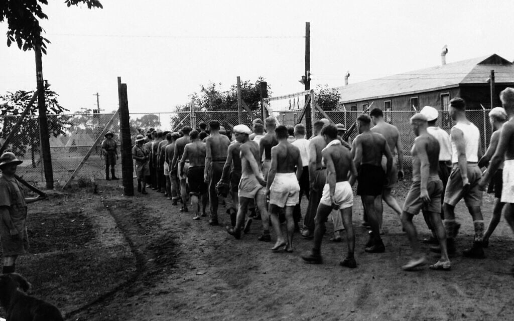 Des prisonniers de guerre nazis rentrent de leur journée de travail dans les champs d'un camp d'internement canadien, le 28 août 1940. (Crédit : AP Photo)