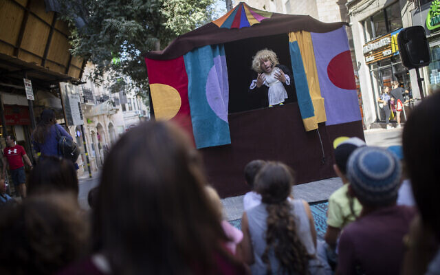 Des artistes de rue divertissent les enfants en vacances d'été sur Ben Yehuda Street dans le centre de Jérusalem, le 13 août 2019 (Crédit : Hadas Parush/Flash90)