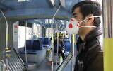 Des Israéliens portant des masques dans un bus à Jérusalem, le 17 mars 2020. (Yossi Zamir/Flash90)